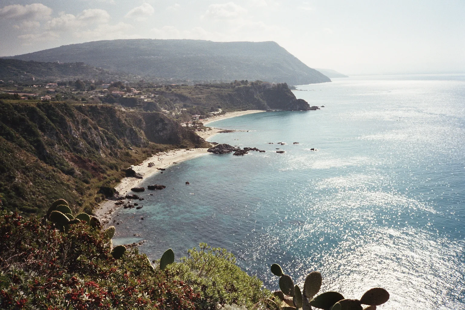 Cliffs and coves of Capo Vaticano above turquoise sea.