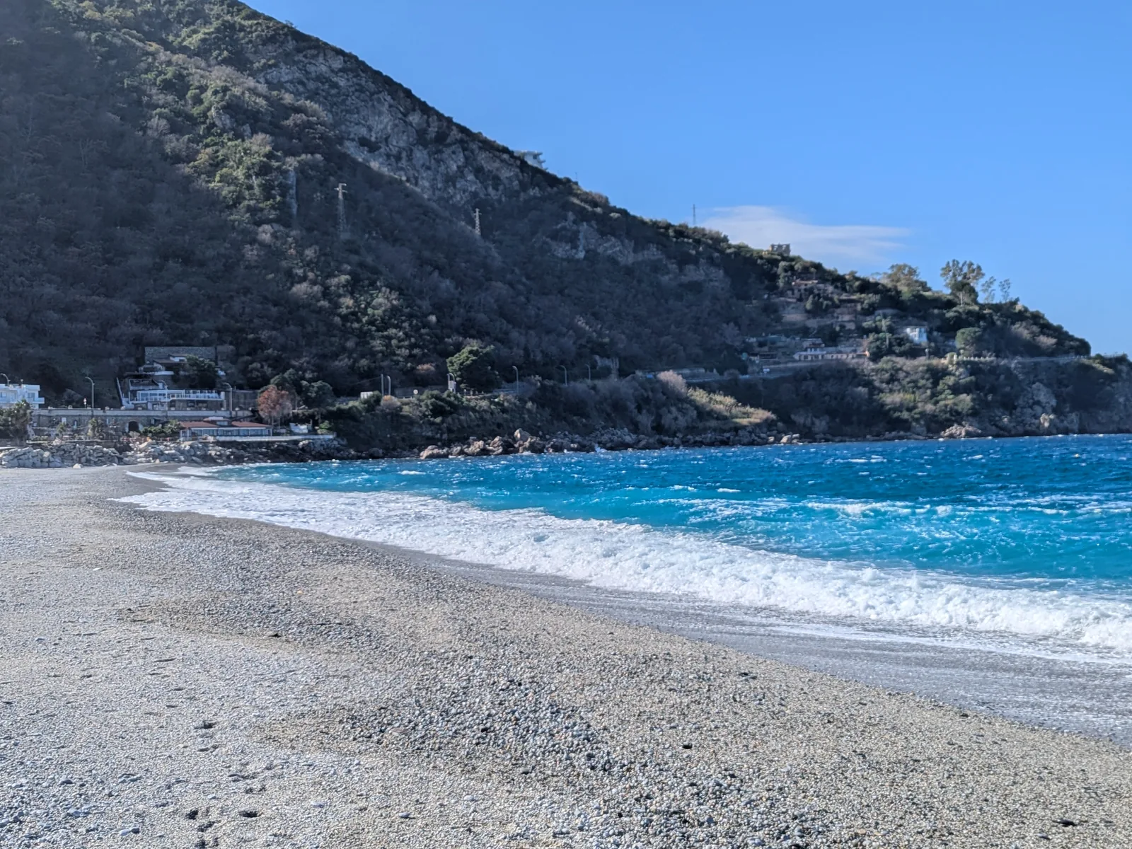 Waves on Marina Grande beach and the Costa Viola hills